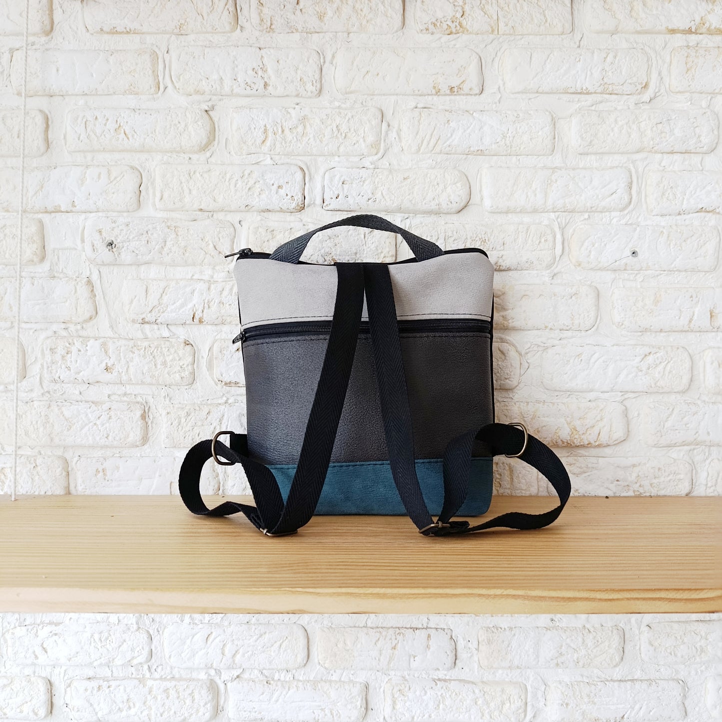 Mochila cuadrada de fondo negro, con azul y gris