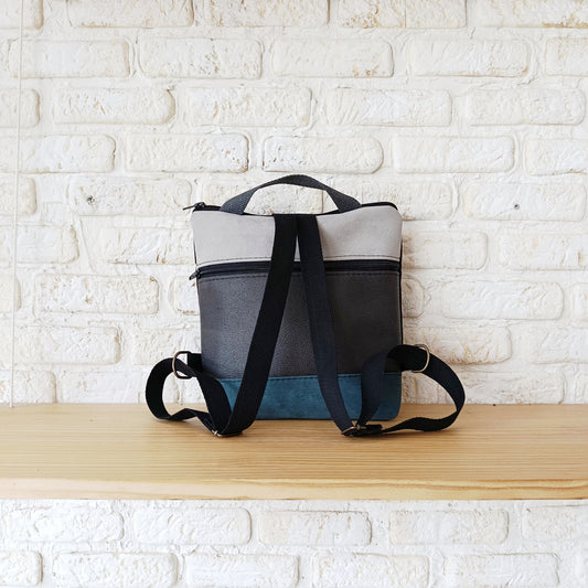 Mochila cuadrada de fondo negro, con azul y gris