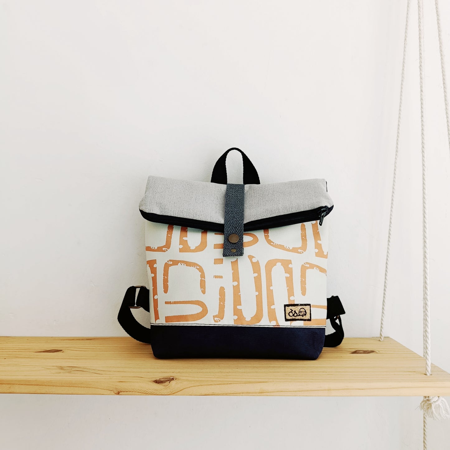 Mochila de solapa con formas orgánicas naranjas y juego de grises