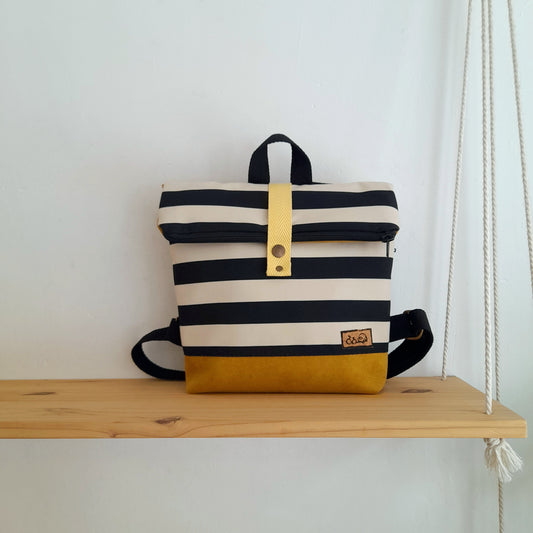 Mochila de solapa con rayas blanco y negro, y base mostaza